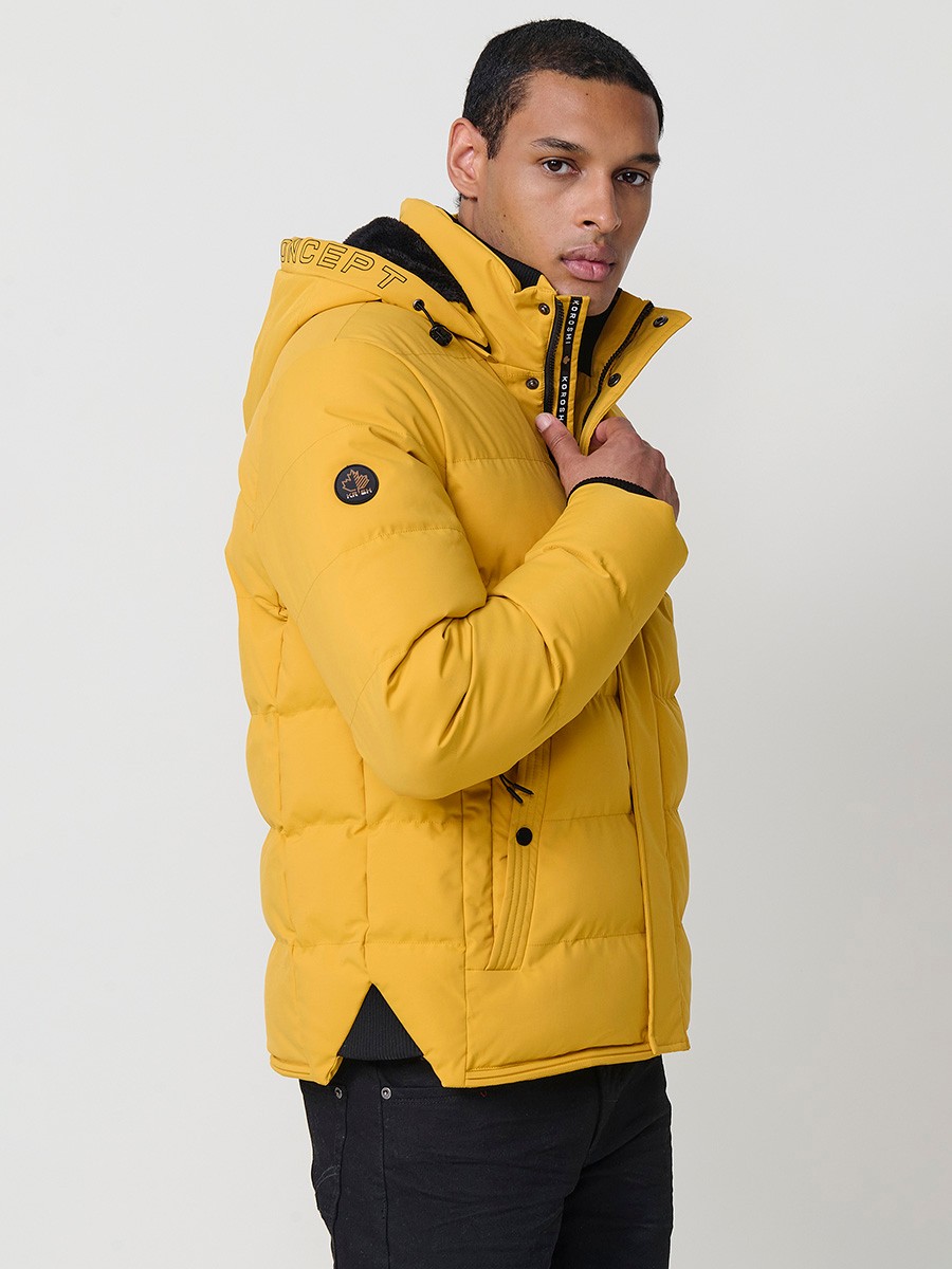 Gesteppte gelbe Herrenjacke mit hohem Kragen, Kapuze, Reißverschluss und Taschen. Aus 100 % Polyester, warm, leicht und strapazierfähig.