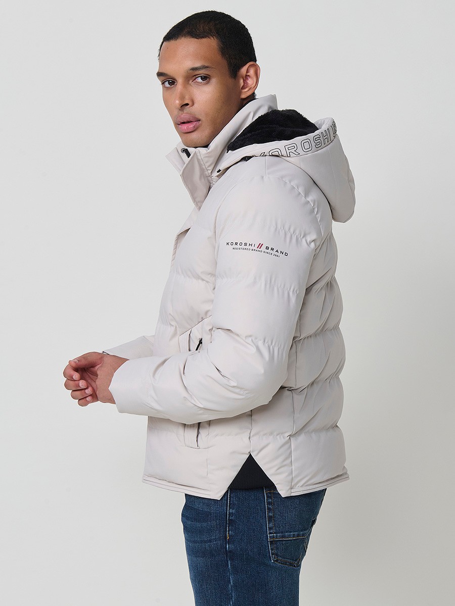Gesteppte steinfarbene Herrenjacke mit hohem Kragen, Kapuze, Reißverschluss und Taschen. Aus 100 % Polyester, warm, strapazierfähig und leicht.