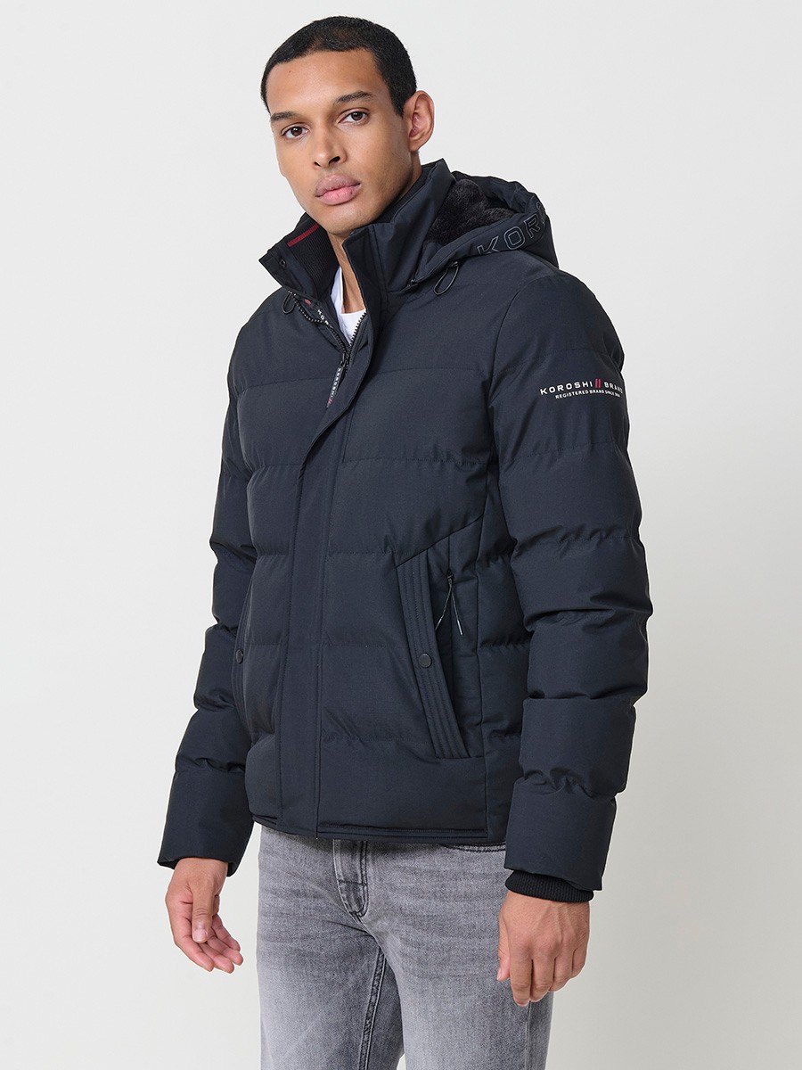 Gesteppte anthrazitfarbene Herrenjacke mit hohem Kragen, Kapuze, Reißverschluss und Taschen. Aus 100 % Polyester, warm, strapazierfähig und leicht.