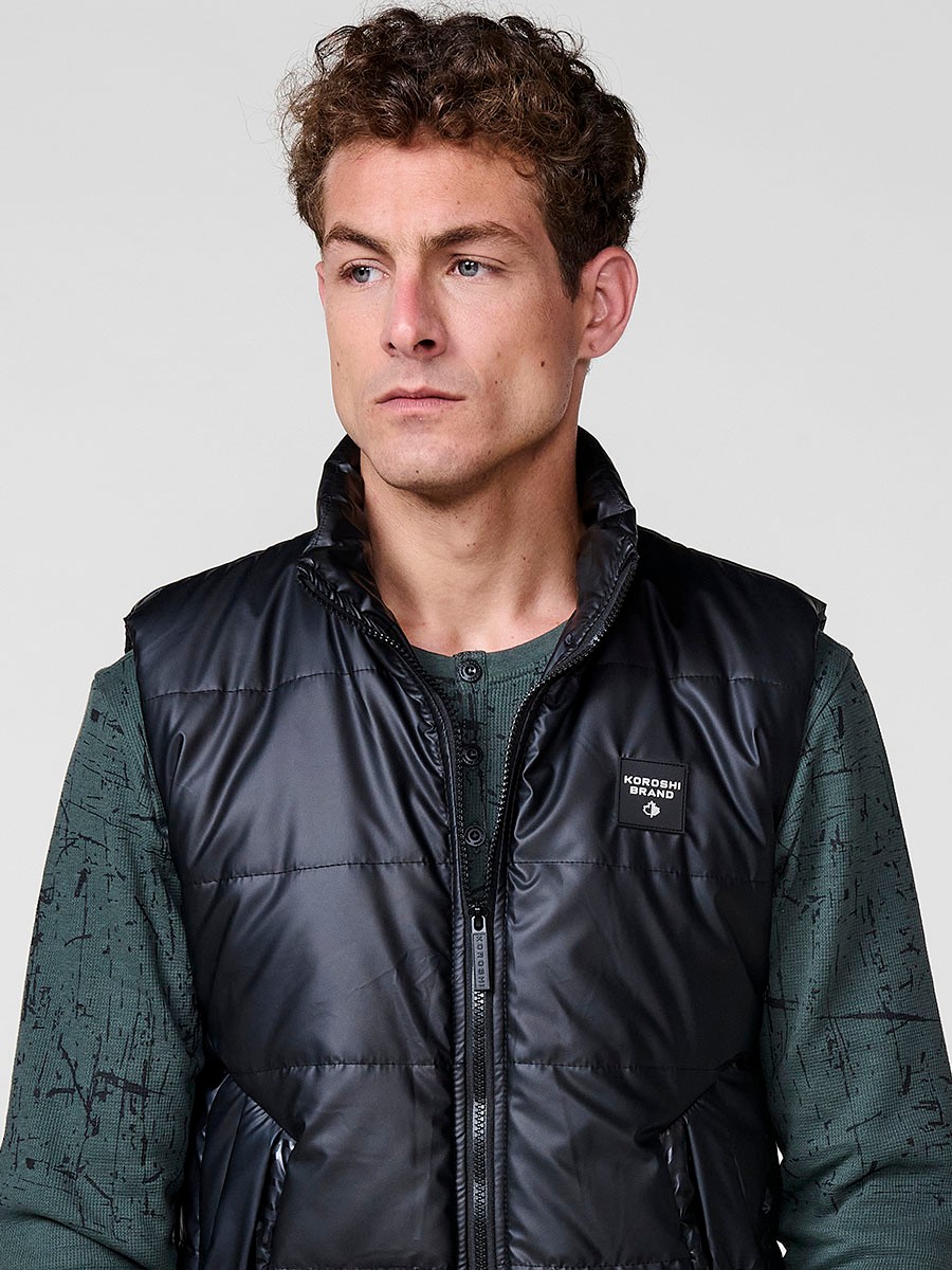 Schwarze gesteppte Herrenweste mit hohem Kragen und Frontreißverschluss. Aus 100 % Polyester, warm, leicht und strapazierfähig.