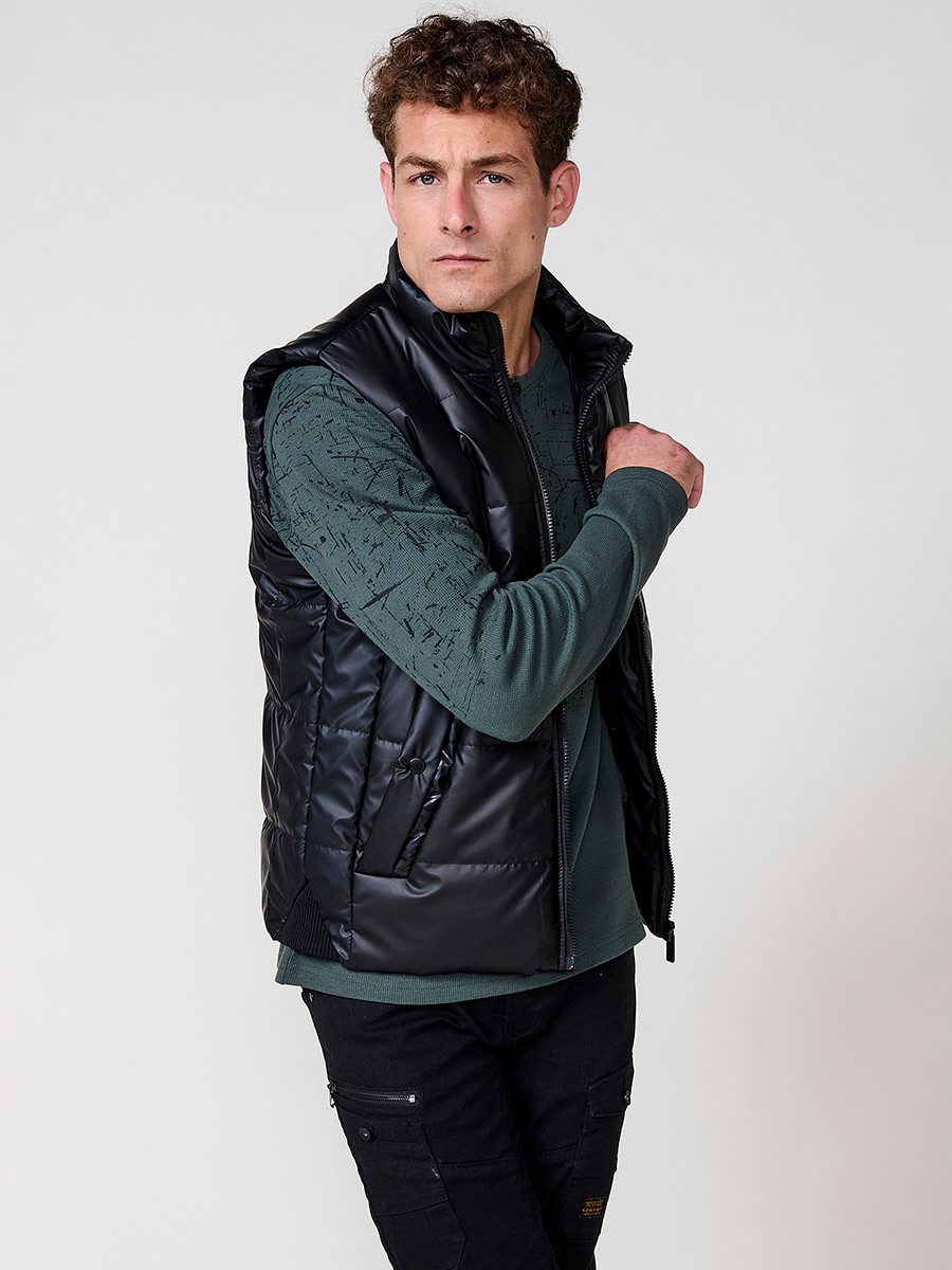 Schwarze gesteppte Herrenweste mit hohem Kragen und Frontreißverschluss. Aus 100 % Polyester, warm, leicht und strapazierfähig.