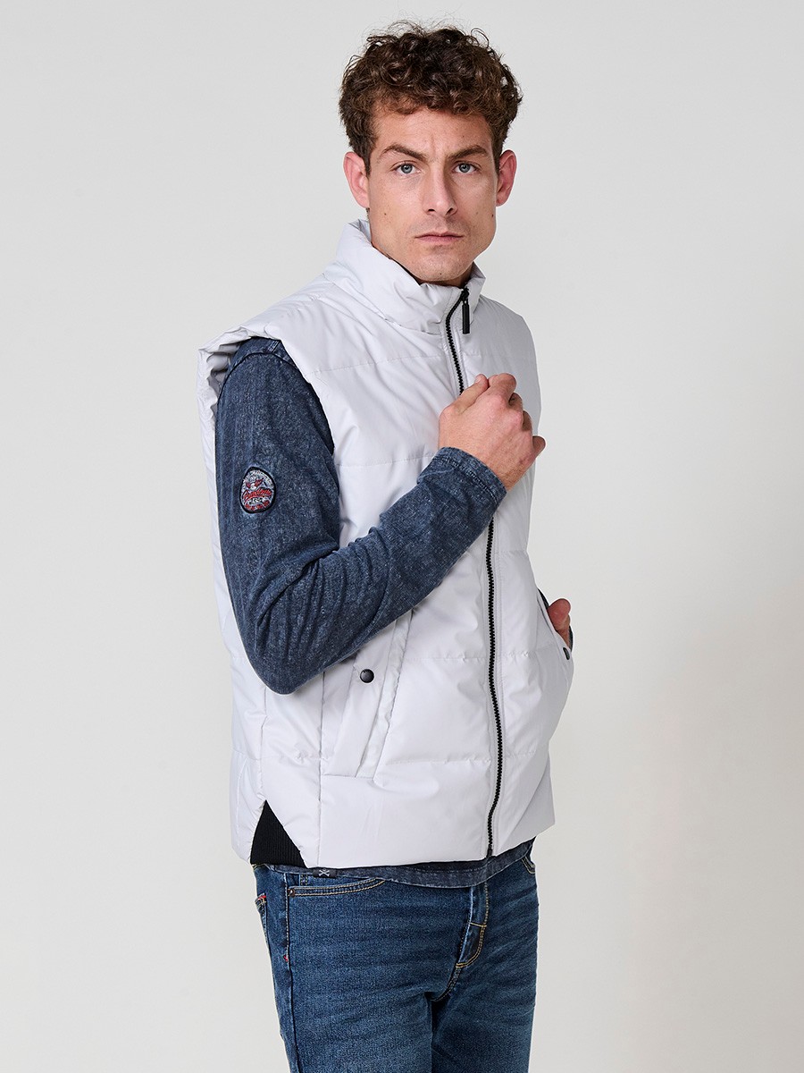 : Perlgraue gesteppte Herrenweste mit hohem Kragen und Frontreißverschluss. Aus 100 % Polyester, warm, leicht und strapazierfähig.