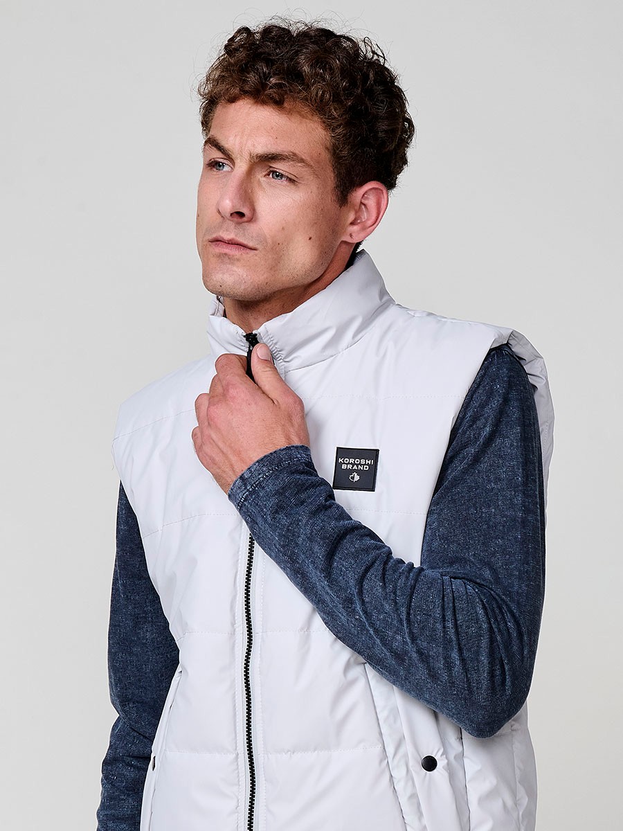 : Perlgraue gesteppte Herrenweste mit hohem Kragen und Frontreißverschluss. Aus 100 % Polyester, warm, leicht und strapazierfähig.
