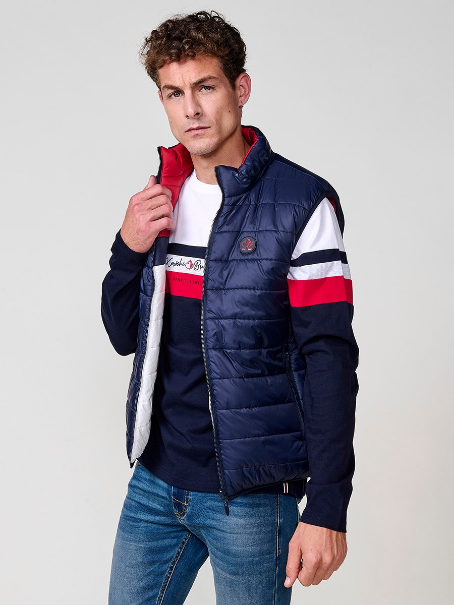 Armilla encoixinada reversible d’home navy amb coll alt i cremallera. Confeccionada en 100 % polièster, pràctica, lleugera i versàtil.