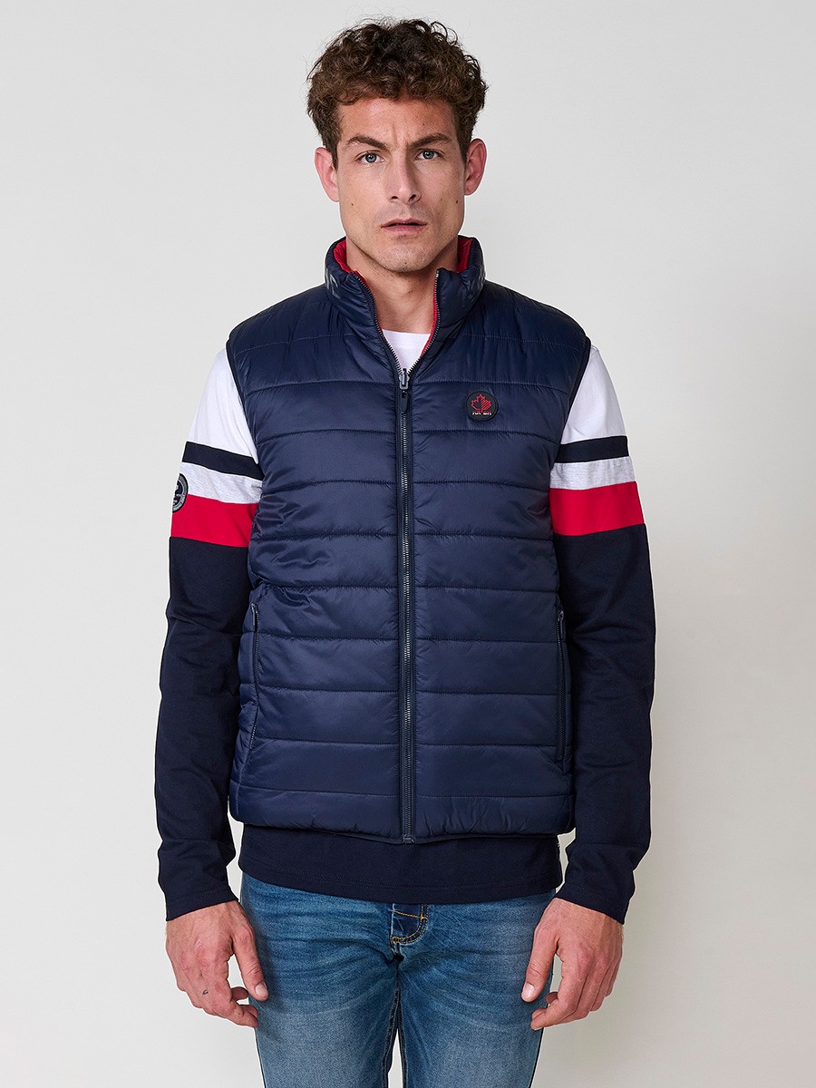 Armilla encoixinada reversible d’home navy amb coll alt i cremallera. Confeccionada en 100 % polièster, pràctica, lleugera i versàtil.