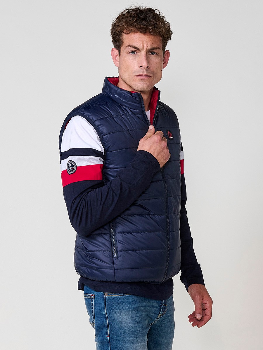 Armilla encoixinada reversible d’home navy amb coll alt i cremallera. Confeccionada en 100 % polièster, pràctica, lleugera i versàtil.