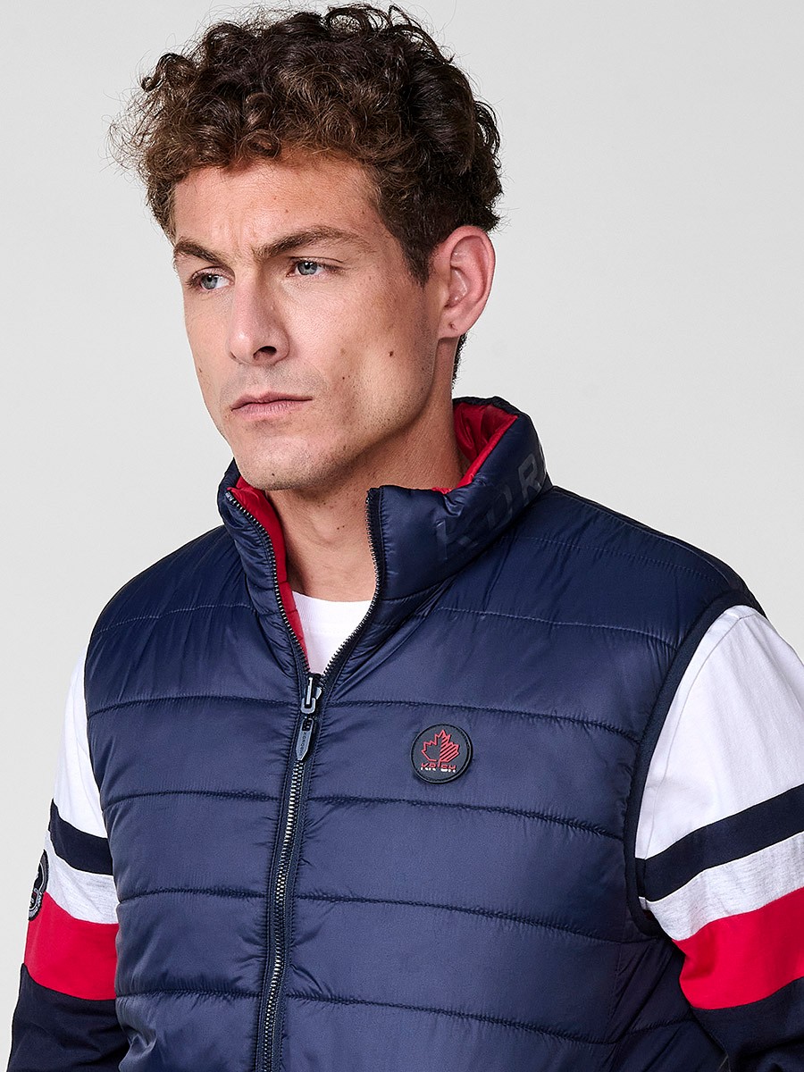 Armilla encoixinada reversible d’home navy amb coll alt i cremallera. Confeccionada en 100 % polièster, pràctica, lleugera i versàtil.