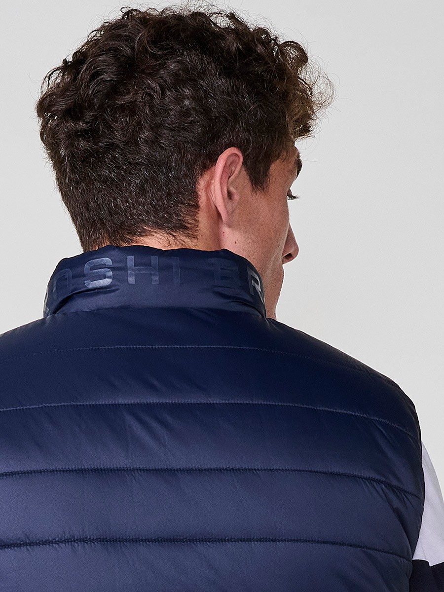 Armilla encoixinada reversible d’home navy amb coll alt i cremallera. Confeccionada en 100 % polièster, pràctica, lleugera i versàtil.