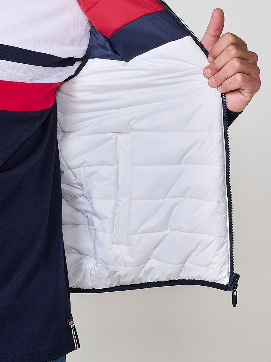 Armilla encoixinada reversible d’home navy amb coll alt i cremallera. Confeccionada en 100 % polièster, pràctica, lleugera i versàtil.