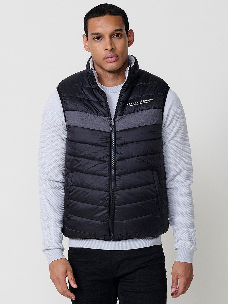 Armilla encoixinada reversible d’home gris perla amb coll alt i cremallera frontal. Confeccionada en 100 % polièster, pràctica, lleugera i versàtil.