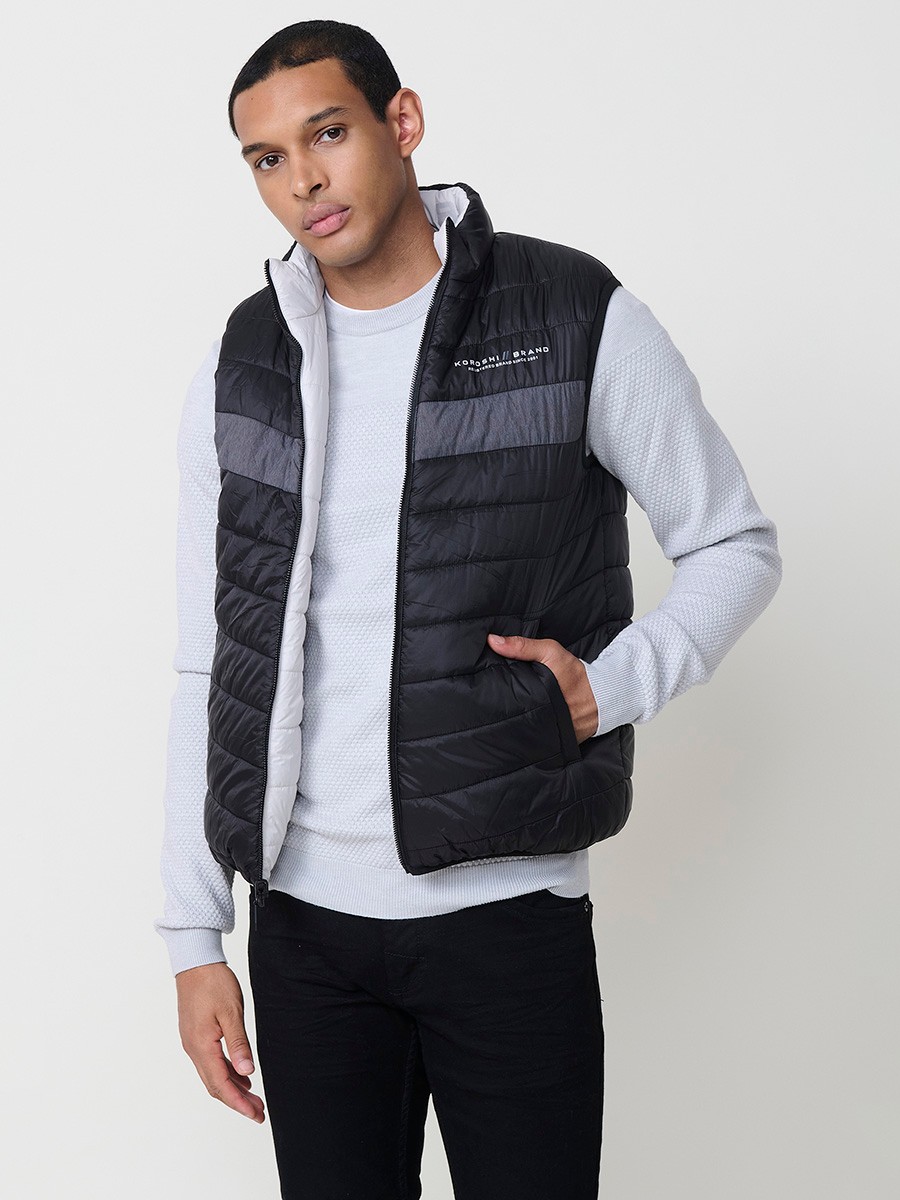 Armilla encoixinada reversible d’home gris perla amb coll alt i cremallera frontal. Confeccionada en 100 % polièster, pràctica, lleugera i versàtil.