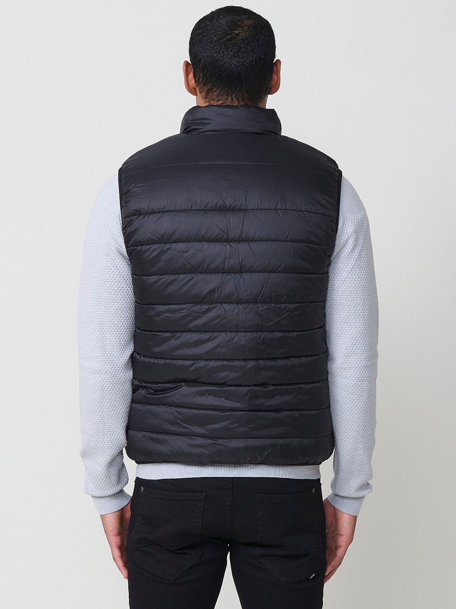Armilla encoixinada reversible d’home gris perla amb coll alt i cremallera frontal. Confeccionada en 100 % polièster, pràctica, lleugera i versàtil.