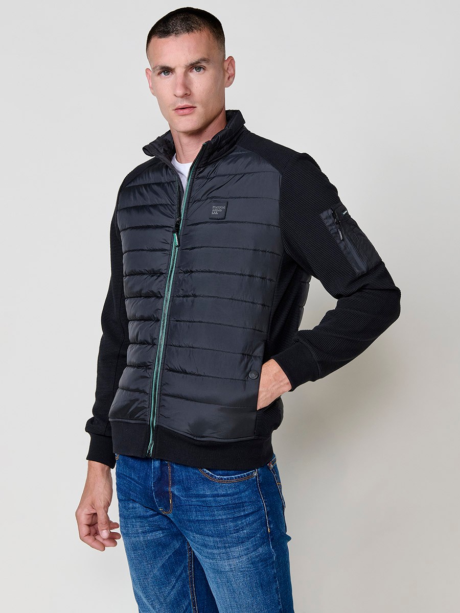Chaqueta de hombre negra acolchada en felpa, confeccionada en 100% poliéster. Cálida, ligera y versátil, ideal para looks urbanos y casuales.