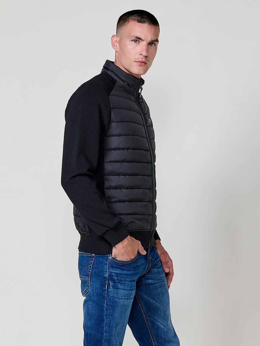 Chaqueta de hombre negra acolchada en felpa, confeccionada en 100% poliéster. Cálida, ligera y versátil, ideal para looks urbanos y casuales.