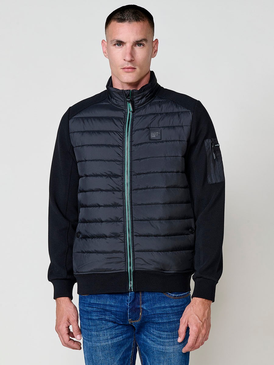 Chaqueta de hombre negra acolchada en felpa, confeccionada en 100% poliéster. Cálida, ligera y versátil, ideal para looks urbanos y casuales.