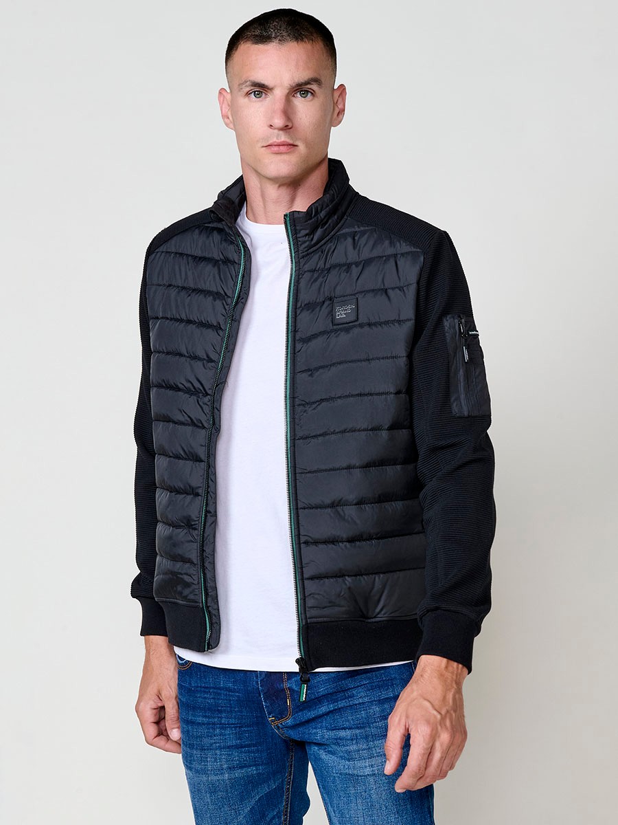 Chaqueta de hombre negra acolchada en felpa, confeccionada en 100% poliéster. Cálida, ligera y versátil, ideal para looks urbanos y casuales.