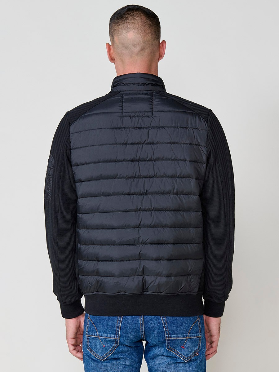 Chaqueta de hombre negra acolchada en felpa, confeccionada en 100% poliéster. Cálida, ligera y versátil, ideal para looks urbanos y casuales.