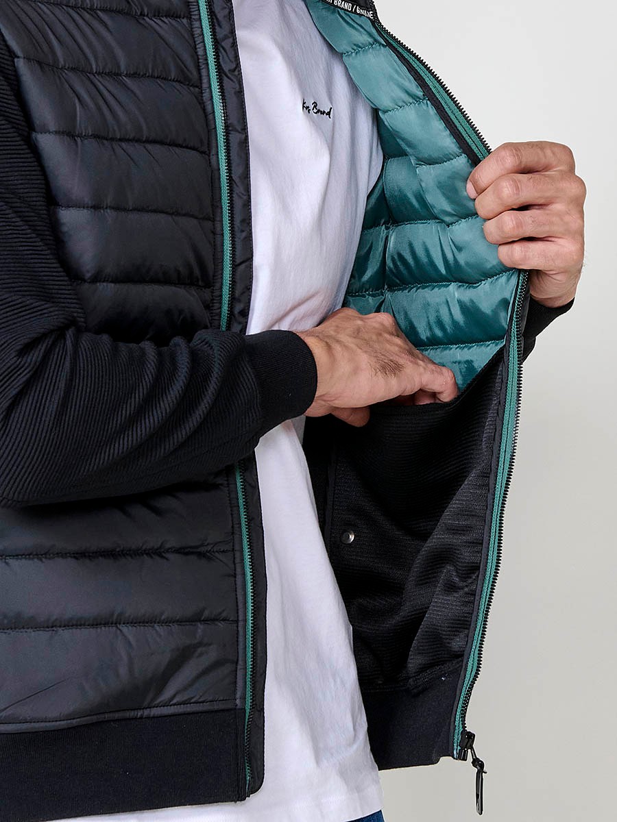 Chaqueta de hombre negra acolchada en felpa, confeccionada en 100% poliéster. Cálida, ligera y versátil, ideal para looks urbanos y casuales.