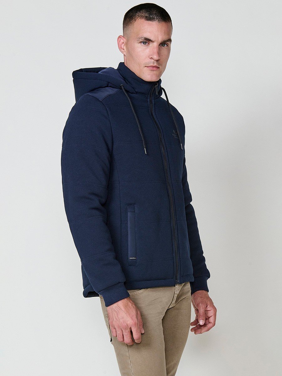 Gesteppte Herrenjacke in Navy mit abnehmbarer Kapuze, hohem Kragen und Reißverschluss. Aus 100 % Polyester, warm, strapazierfähig und vielseitig.