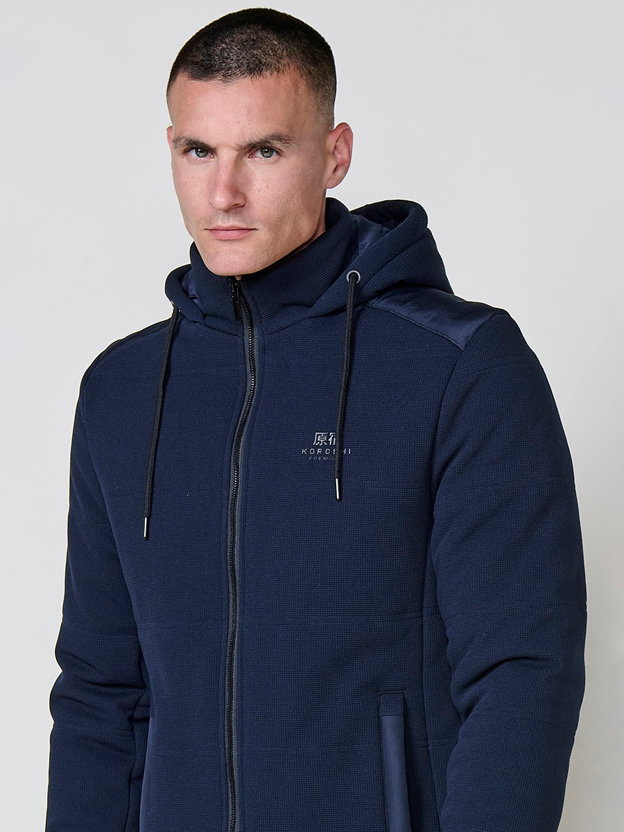Gesteppte Herrenjacke in Navy mit abnehmbarer Kapuze, hohem Kragen und Reißverschluss. Aus 100 % Polyester, warm, strapazierfähig und vielseitig.