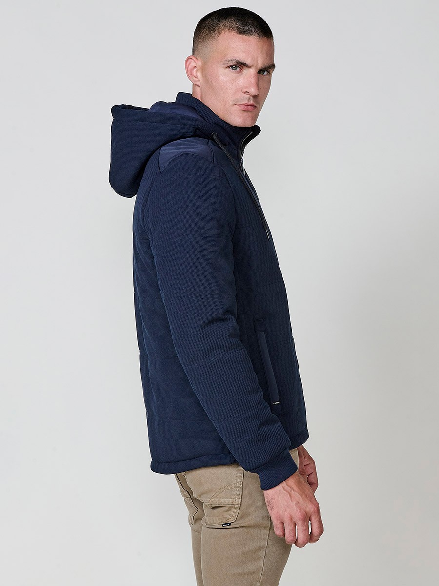 Gesteppte Herrenjacke in Navy mit abnehmbarer Kapuze, hohem Kragen und Reißverschluss. Aus 100 % Polyester, warm, strapazierfähig und vielseitig.