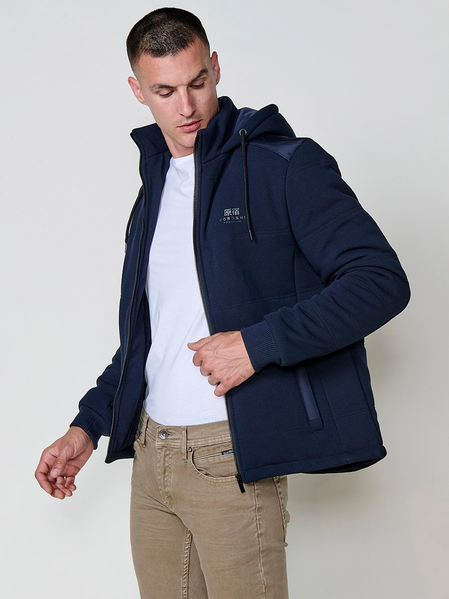 Gesteppte Herrenjacke in Navy mit abnehmbarer Kapuze, hohem Kragen und Reißverschluss. Aus 100 % Polyester, warm, strapazierfähig und vielseitig.