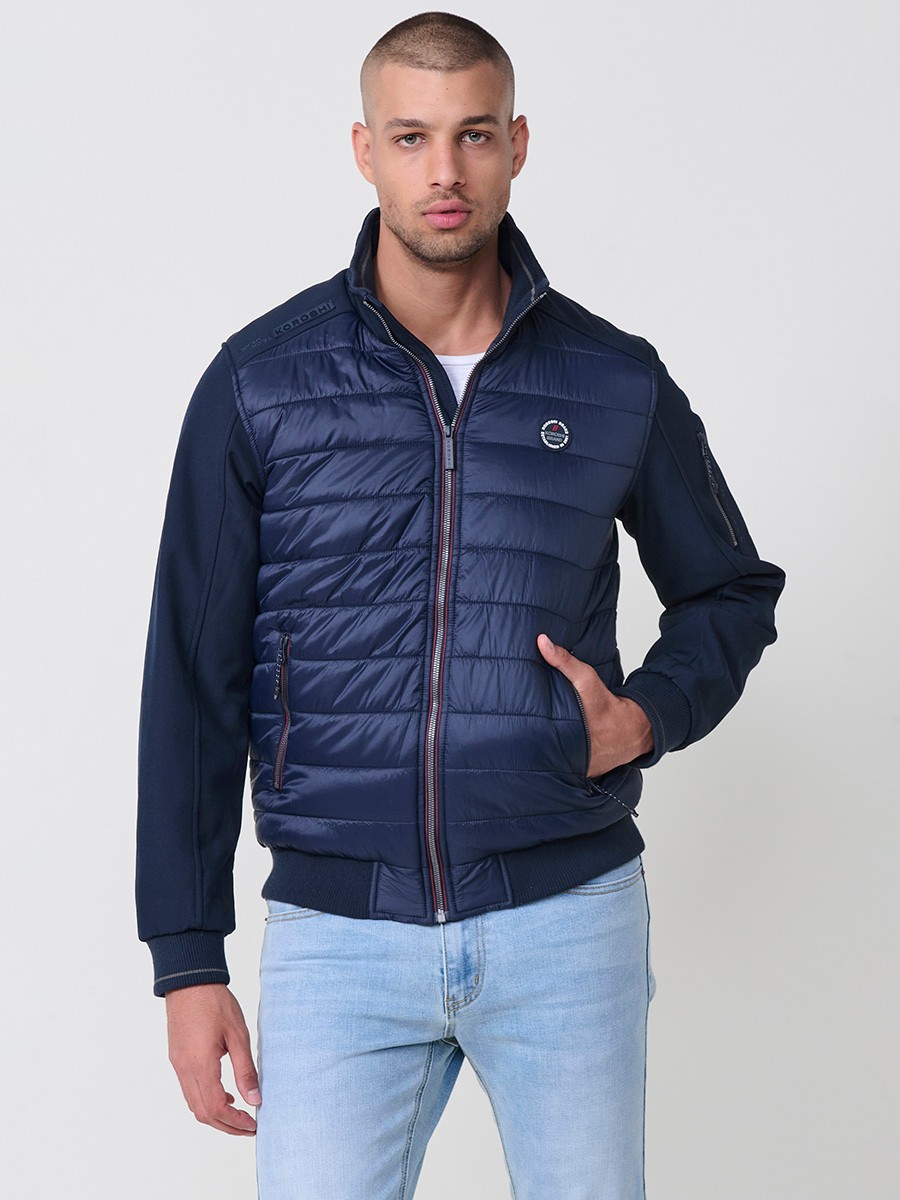 Gesteppte Herrenjacke in Navy mit hohem Kragen, Frontreißverschluss und Taschen. Aus 100 % Polyester, warm, leicht und strapazierfähig.