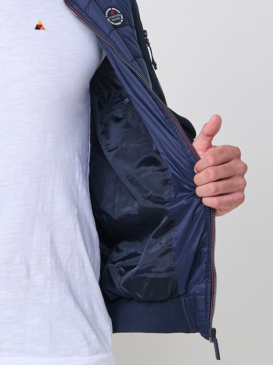Gesteppte Herrenjacke in Navy mit hohem Kragen, Frontreißverschluss und Taschen. Aus 100 % Polyester, warm, leicht und strapazierfähig.