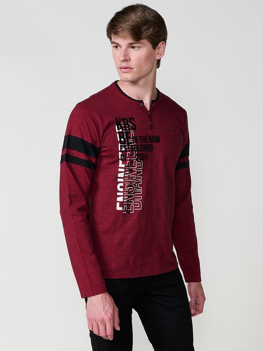 Camiseta de hombre en color rojo, manga larga, cuello redondo con abertura y estampado delantero. Confeccionada en 100% algodón.