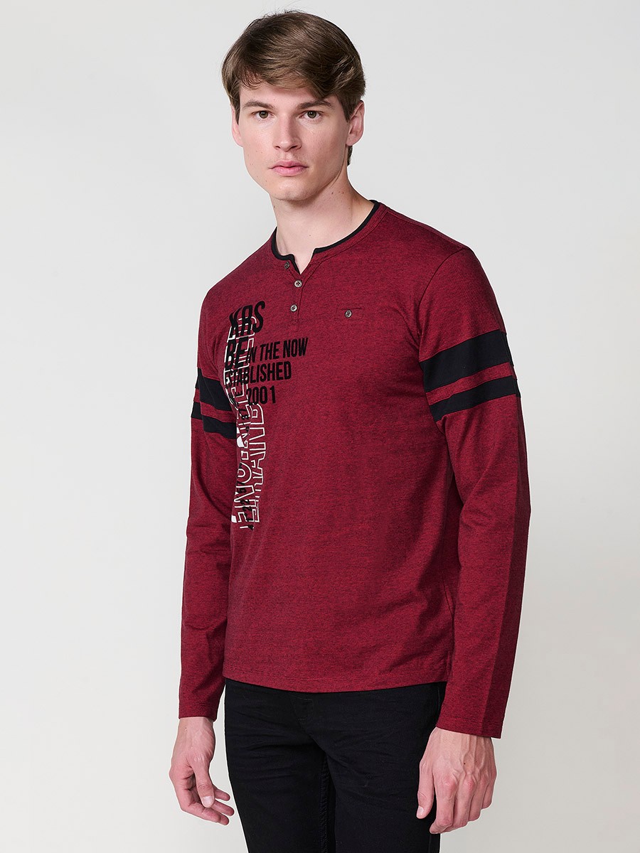 Camiseta de hombre en color rojo, manga larga, cuello redondo con abertura y estampado delantero. Confeccionada en 100% algodón.