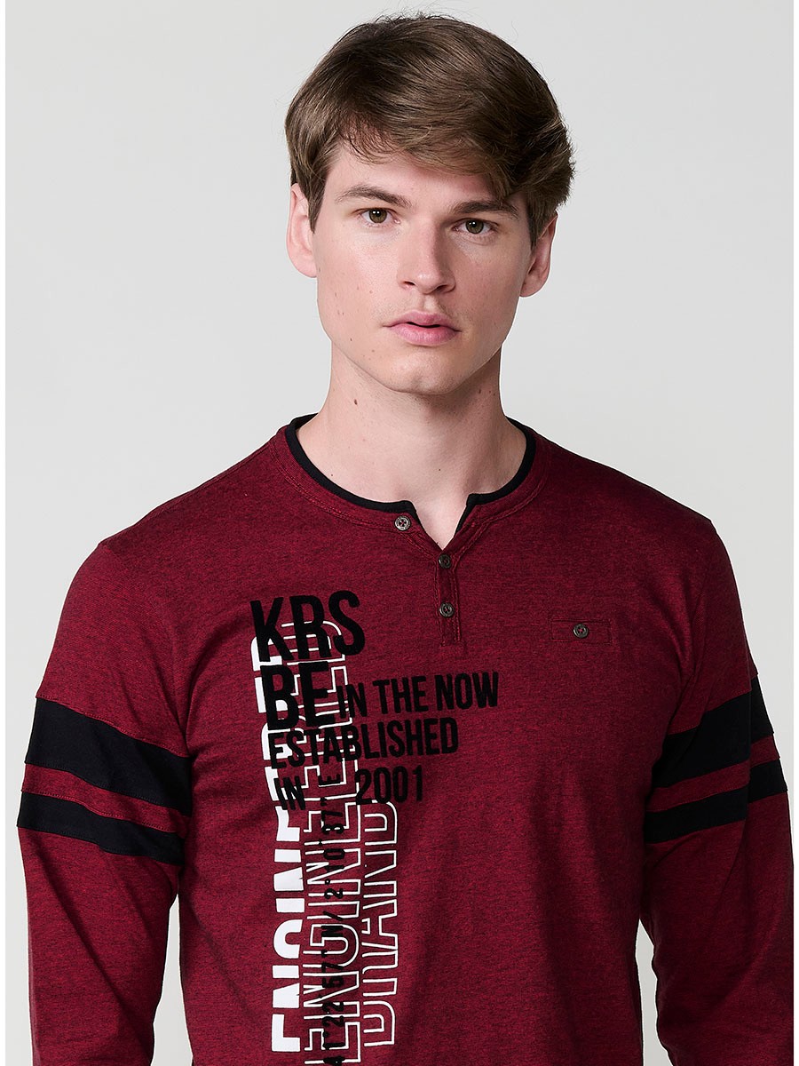 Camiseta de hombre en color rojo, manga larga, cuello redondo con abertura y estampado delantero. Confeccionada en 100% algodón.