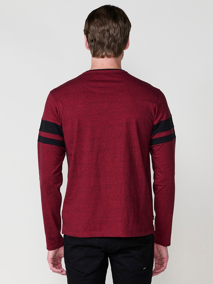 Camiseta de hombre en color rojo, manga larga, cuello redondo con abertura y estampado delantero. Confeccionada en 100% algodón.