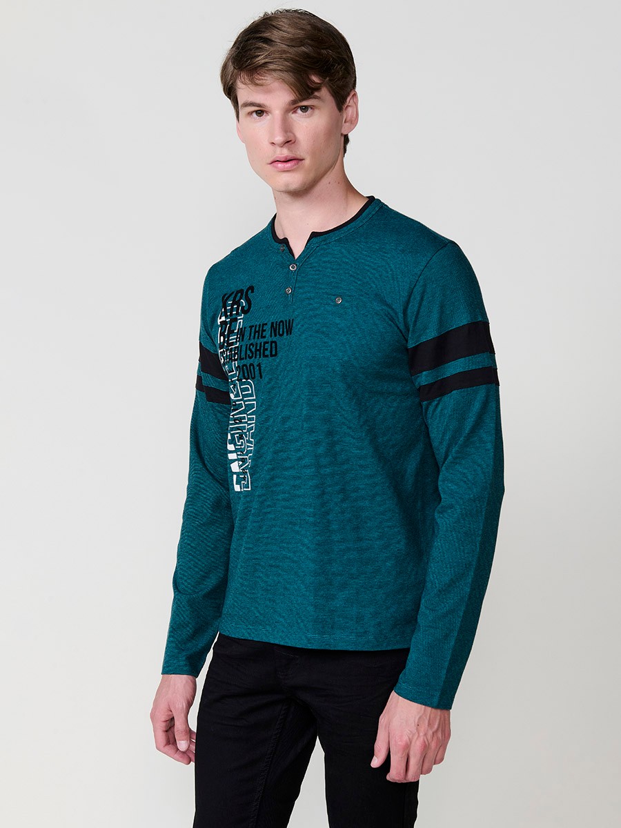 Camiseta de hombre en color petróleo, manga larga, cuello redondo con abertura y estampado delantero. Confeccionada en 100% algodón.