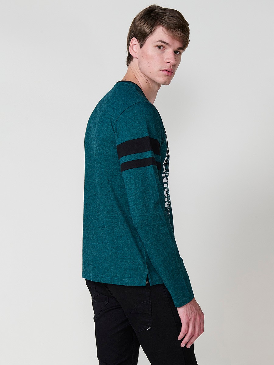 Camiseta de hombre en color petróleo, manga larga, cuello redondo con abertura y estampado delantero. Confeccionada en 100% algodón.