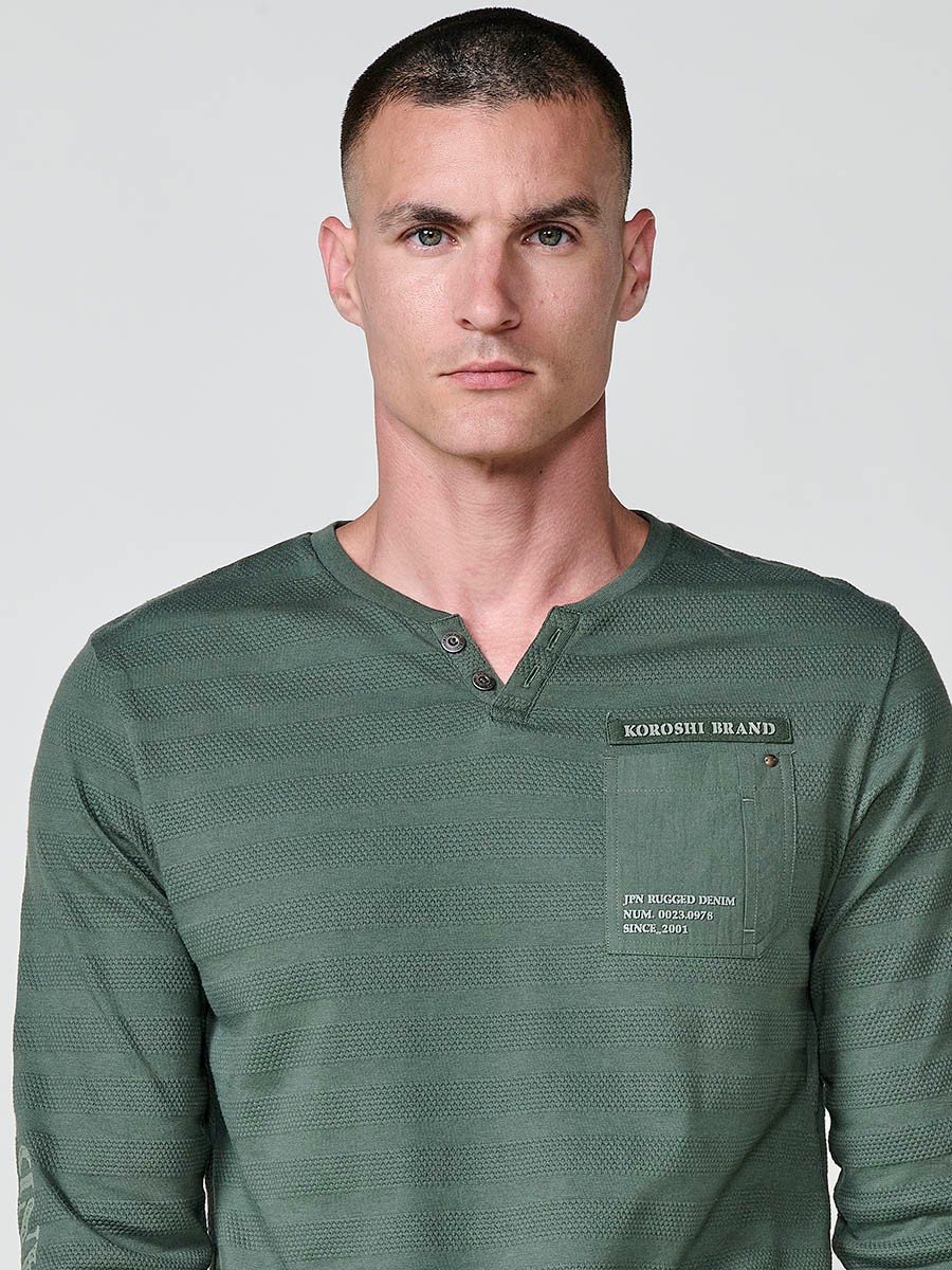 Camiseta de hombre kaki de manga larga, 100% algodón, con cuello redondo con abertura y estampado delantero.