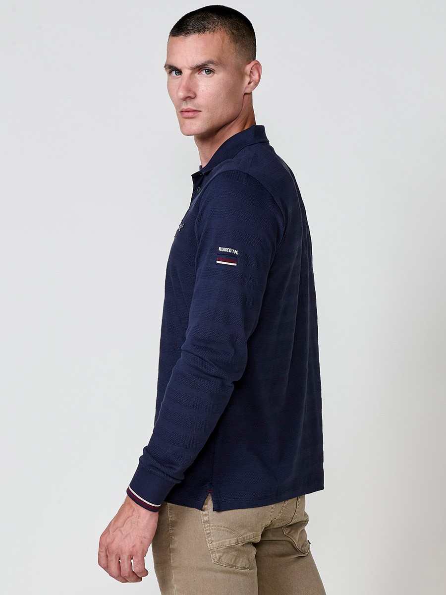 Polo de hombre en color navy, de manga larga y cuello camisero. Prenda masculina básica de algodón 100%.