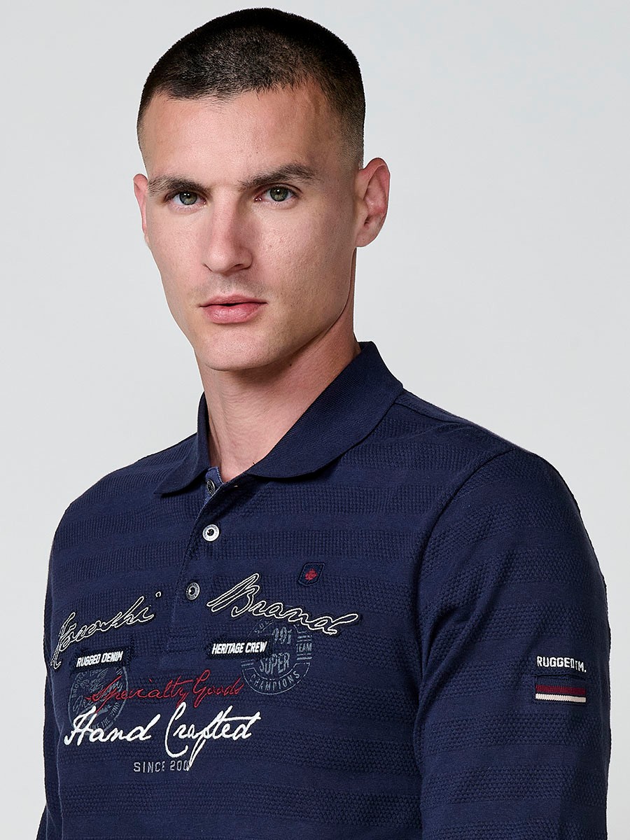 Polo de hombre en color navy, de manga larga y cuello camisero. Prenda masculina básica de algodón 100%.