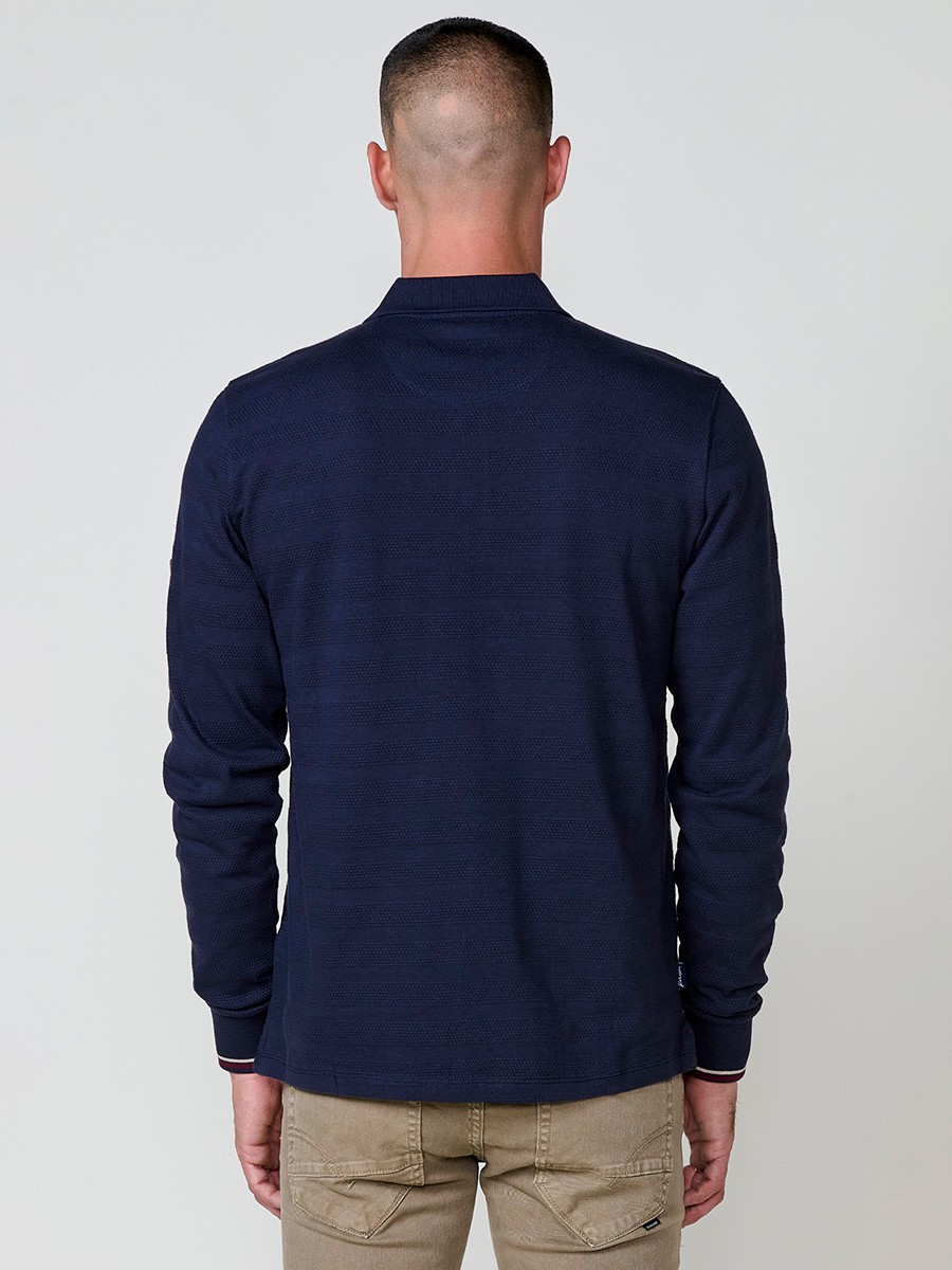Polo de hombre en color navy, de manga larga y cuello camisero. Prenda masculina básica de algodón 100%.