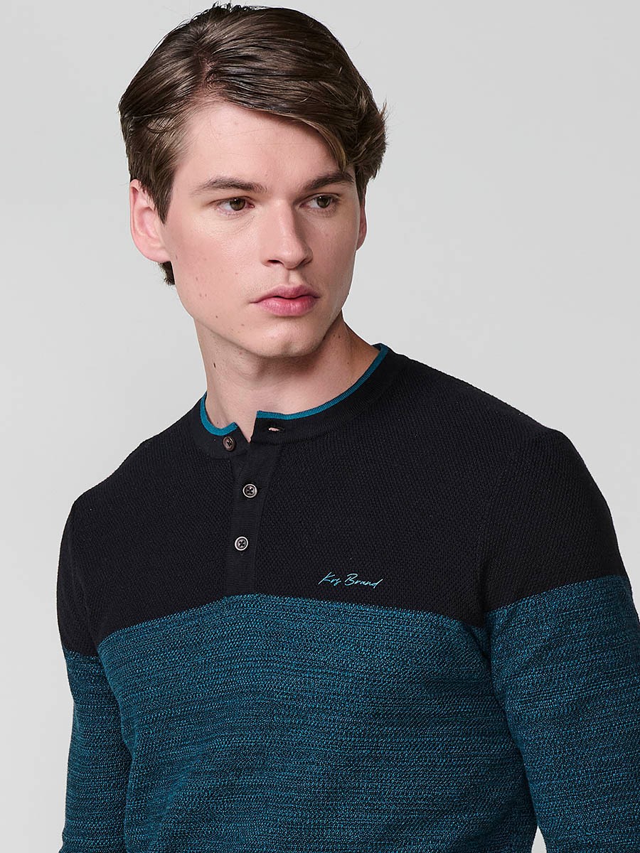Polo de hombre en punto tricot, color negro, con manga larga y cuello redondo abotonado. 100% algodón.