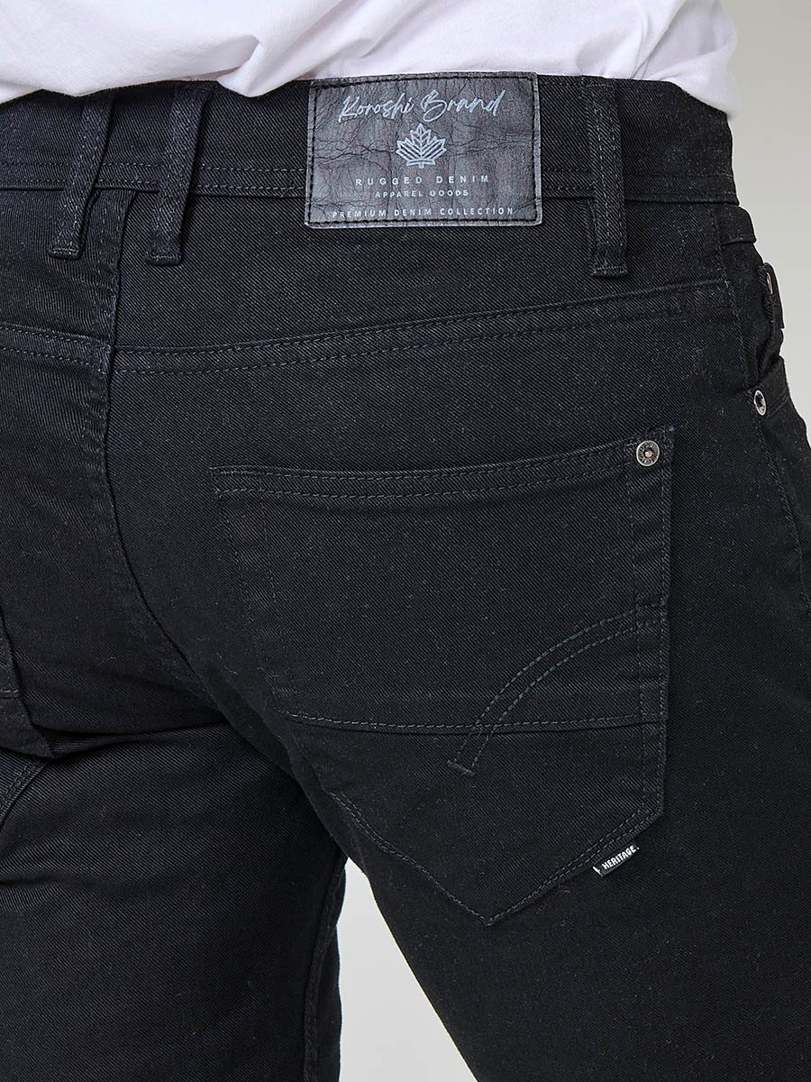 Vaqueros negros elásticos para hombre, corte regular fit, con cierre de cremallera y botón.