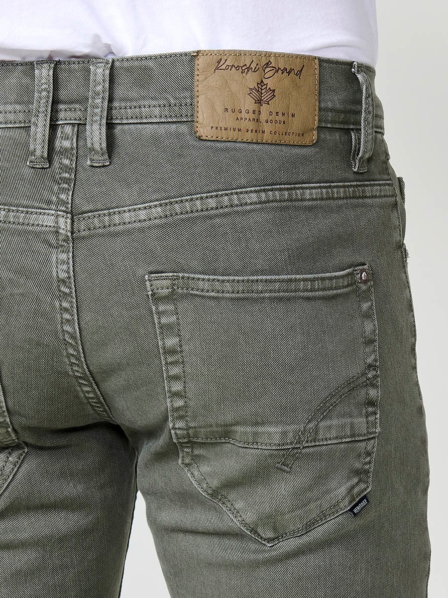 Vaqueros elásticos para hombre en color oliva, corte regular fit con cierre de cremallera y botón.