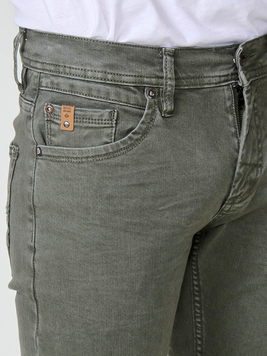 Vaqueros elásticos para hombre en color oliva, corte regular fit con cierre de cremallera y botón.