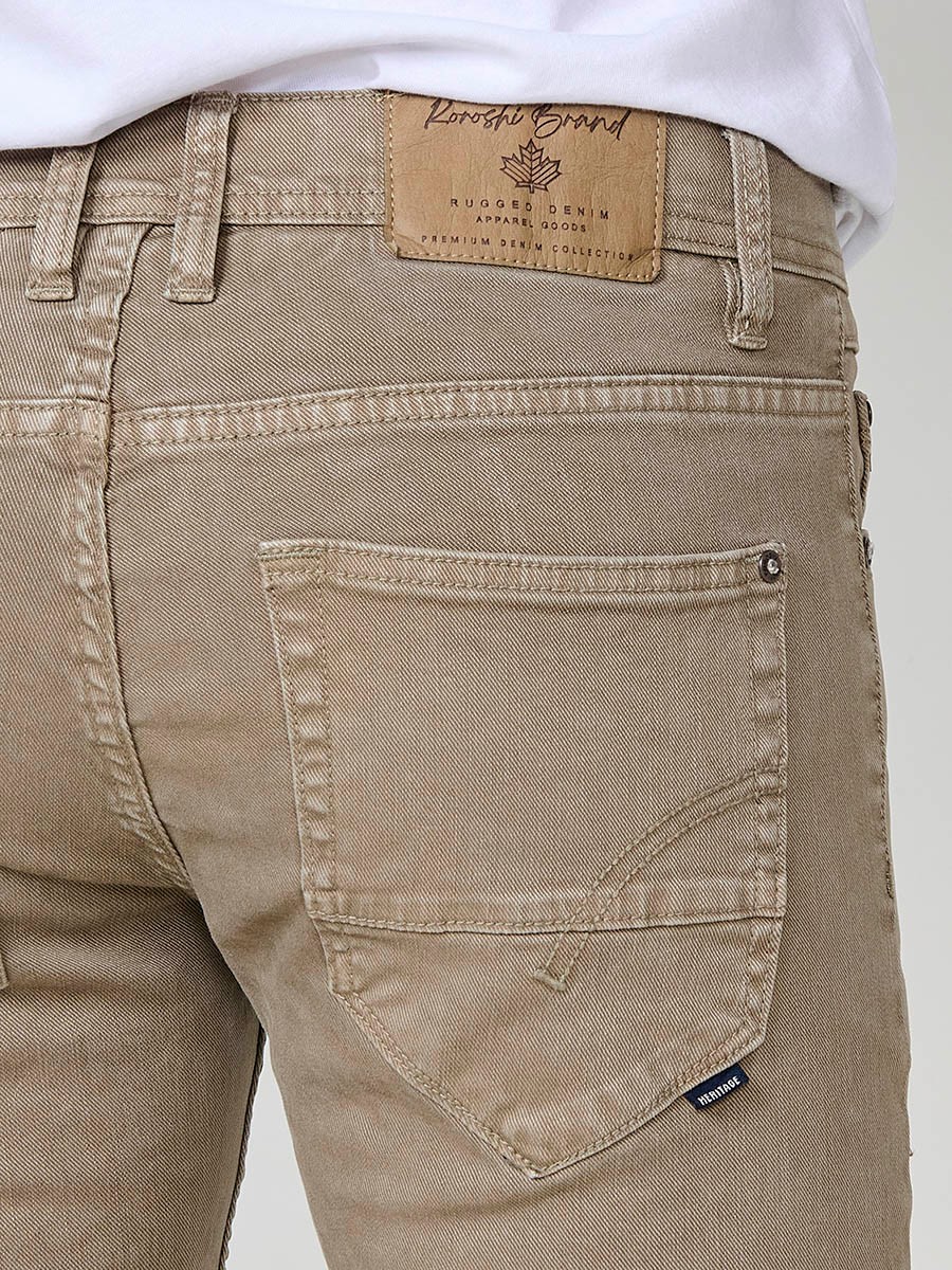 Vaqueros elásticos para hombre en color visón, corte regular fit con cierre de cremallera y botón.