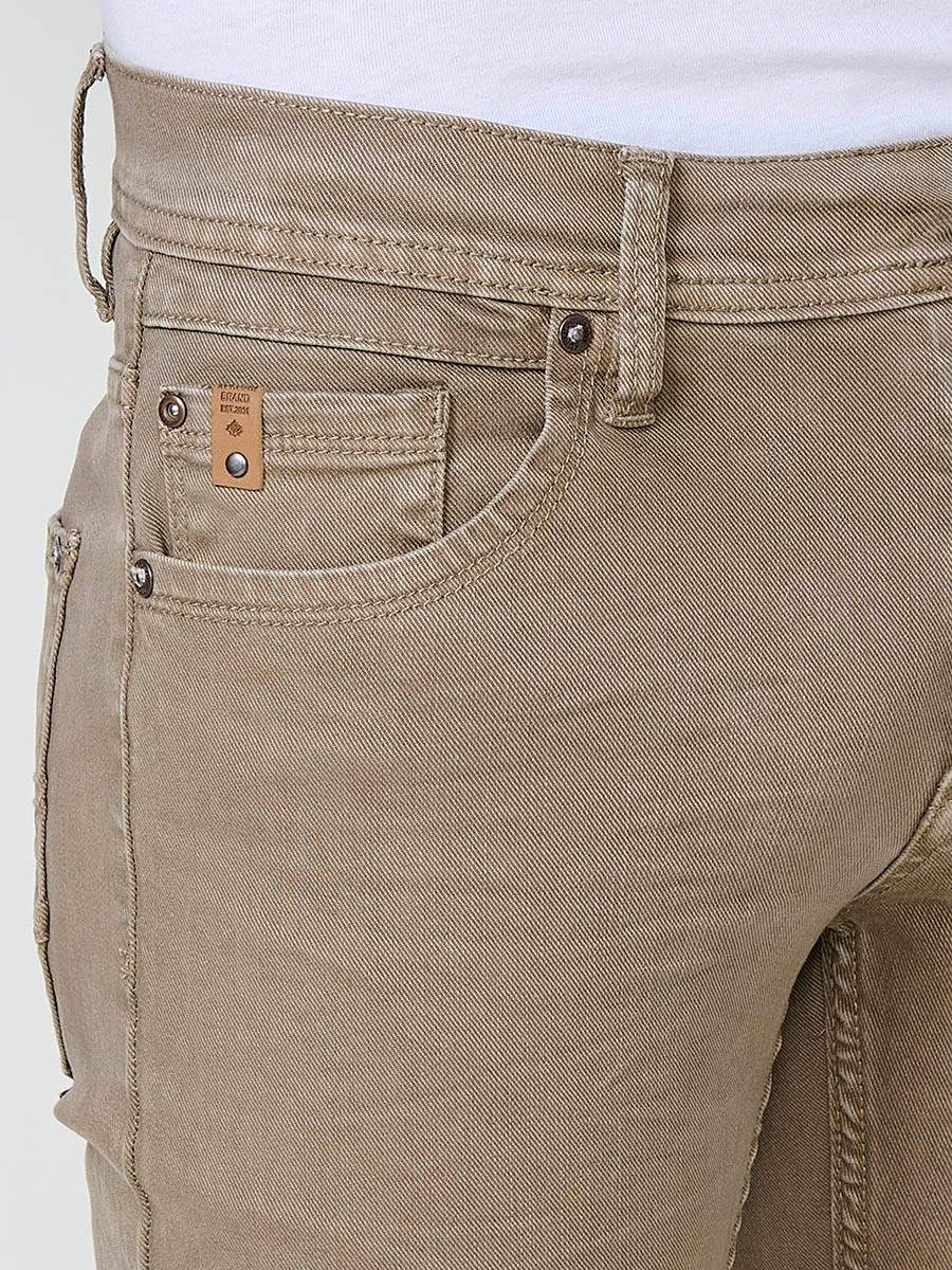 Vaqueros elásticos para hombre en color visón, corte regular fit con cierre de cremallera y botón.