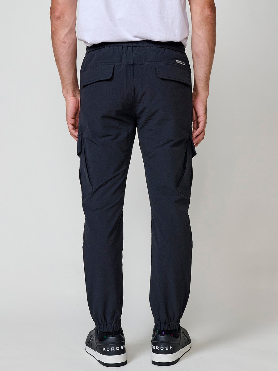 Pantalón jogger largo de hombre negro, 98% algodón y 2% elastano, con bolsillos y cierre delantero con cremallera y botón.