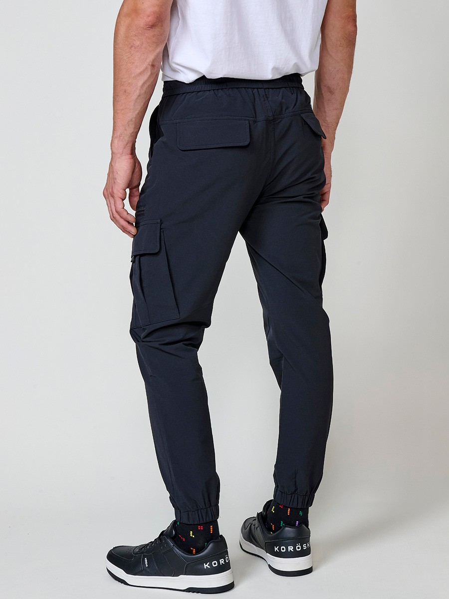 Pantalón jogger largo de hombre negro, 98% algodón y 2% elastano, con bolsillos y cierre delantero con cremallera y botón.