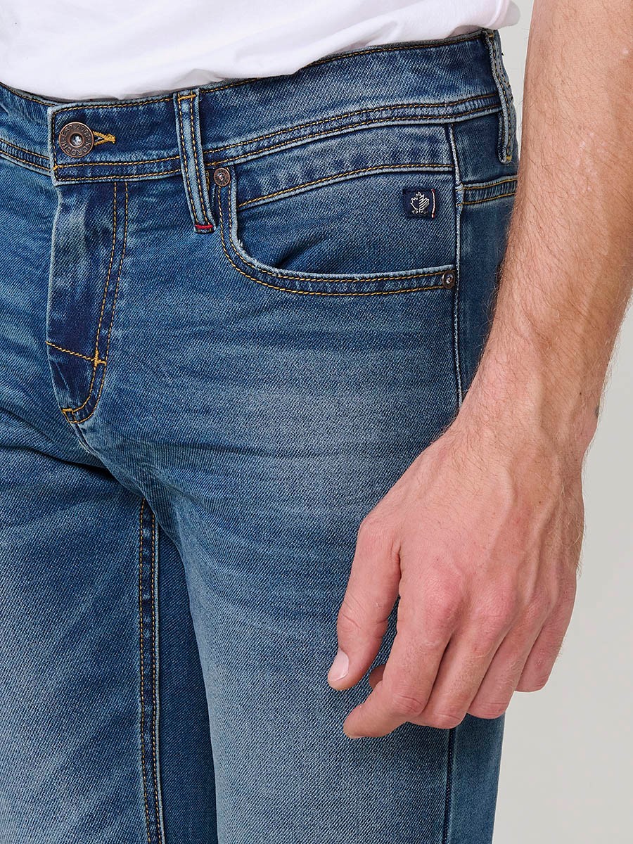 Pantalón vaquero slim fit de hombre en azul oscuro, 98% algodón y 2% elastano, con bolsillos y cierre con cremallera y botón.