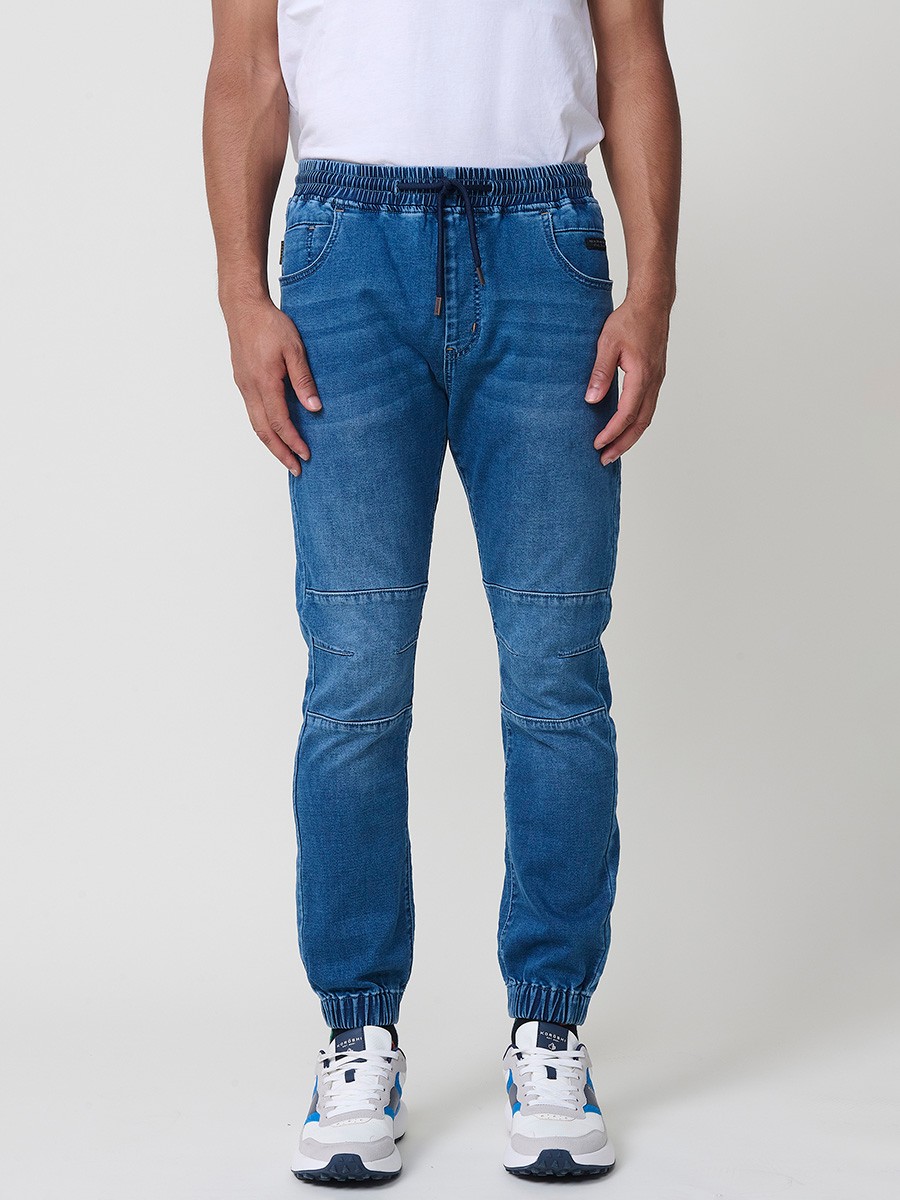 Pantalón jogger de hombre en color azul medio, con bolsillos prácticos y tejido 100% poliéster resistente y cómodo.