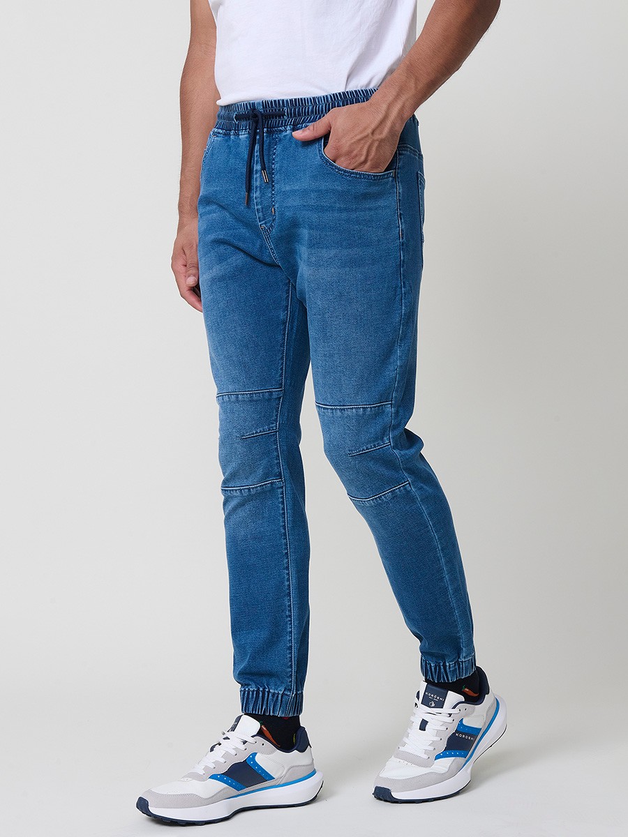 Pantalón jogger de hombre en color azul medio, con bolsillos prácticos y tejido 100% poliéster resistente y cómodo.