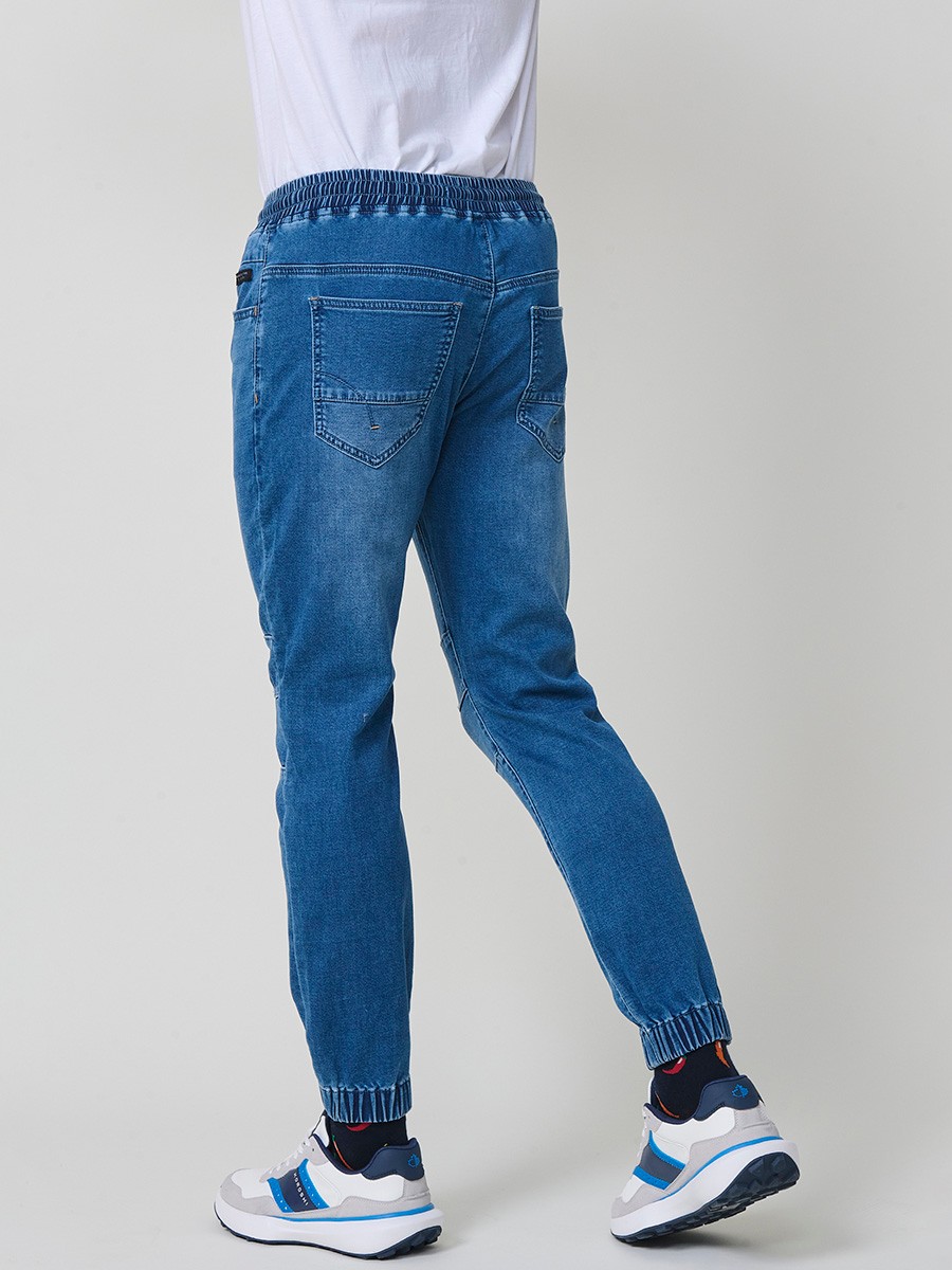Pantalón jogger de hombre en color azul medio, con bolsillos prácticos y tejido 100% poliéster resistente y cómodo.